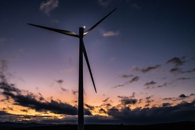 Low angle view of silhouette wind turbine against sky during sunset