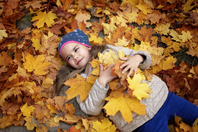 Portrait of boy on leaves during autumn