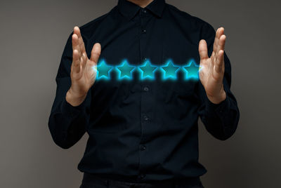 Midsection of man holding hands against white background