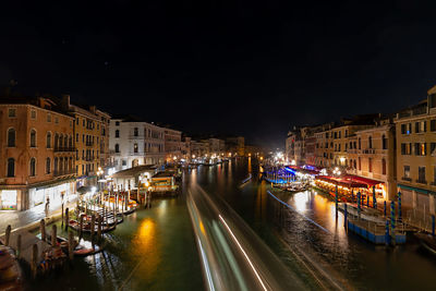 Canal amidst illuminated buildings in the city of venice at night