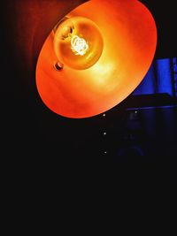 Low angle view of illuminated lamp in darkroom