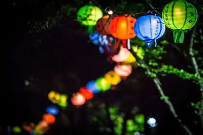 Close-up of illuminated lanterns hanging at night