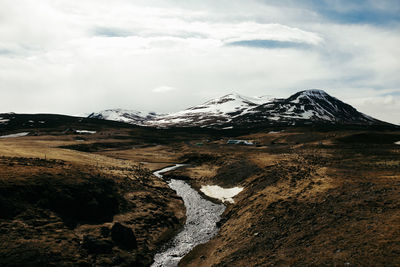 Scenic view of mountains against cloudy sky