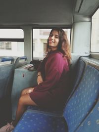 Portrait of smiling woman sitting in train