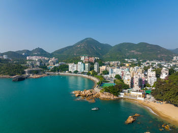 High angle view of townscape by sea against sky