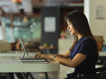 Side view of businesswoman working in office