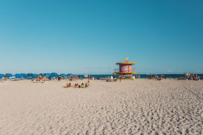 Scenic view of beach against clear blue sky