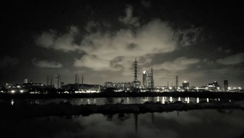 Illuminated cityscape against sky at night