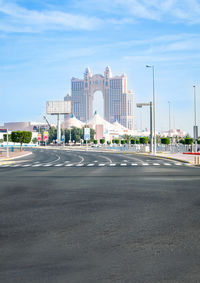 View of city street against cloudy sky