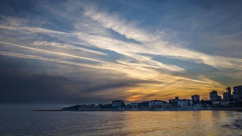 Scenic view of sea against cloudy sky at sunset