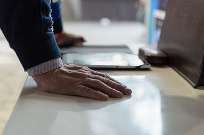 Cropped hands of businessman using digital tablet at desk