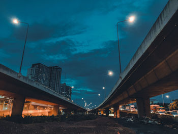 Illuminated street lights against sky at night