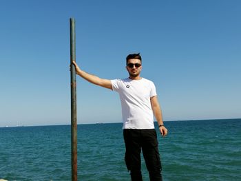 Portrait of man standing in sea against clear sky