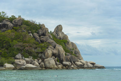 Rocks by sea against sky