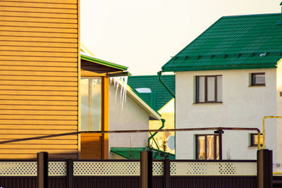 Empty chairs and yellow outside building against sky
