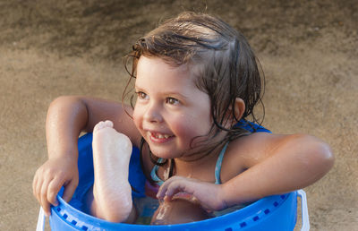 Portrait of smiling boy sitting on sand