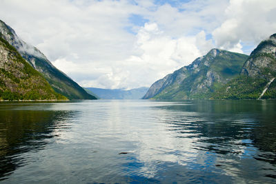 Scenic view of lake by mountains against sky