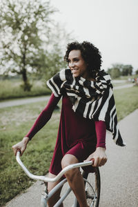 Smiling woman riding bicycle at park