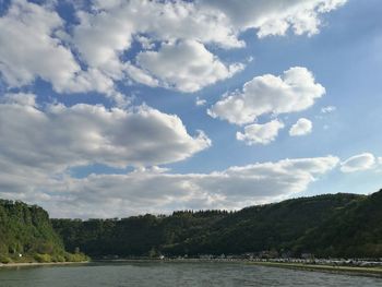 Scenic view of river and mountains against sky