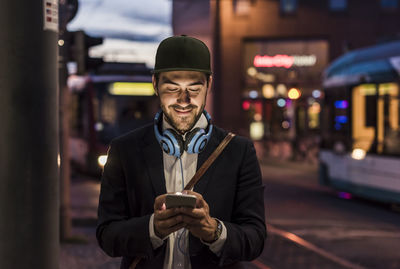 Young man in the city checking cell phone in the evening