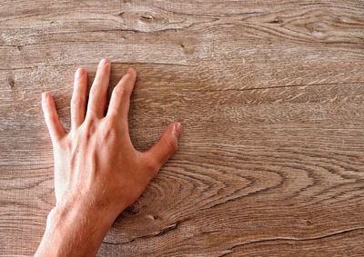 High angle view of human hand on wooden table