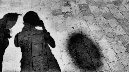 Low section of women standing on shadow