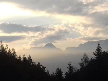 Scenic view of silhouette mountains against sky at sunset