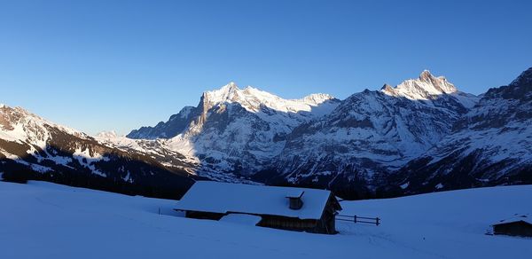 Snow covered mountains against clear blue sky
