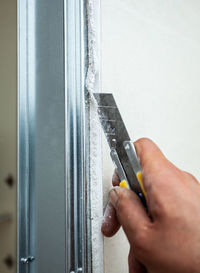 Close-up of person working on metal wall