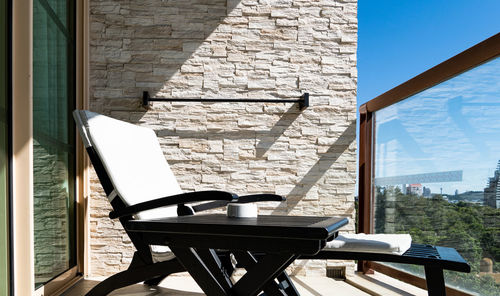 Empty chairs and table against building