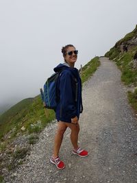 Full length of young man walking on mountain against clear sky