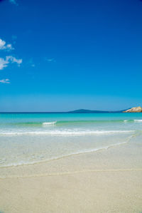 Scenic view of beach against blue sky