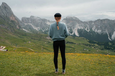 Woman overlooking seceda in dolomite mountains