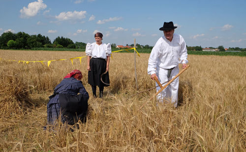 Rear view of man with arms raised on field