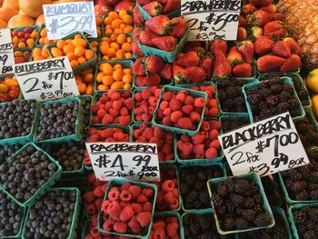 High angle view of berry fruits in containers at market for sale