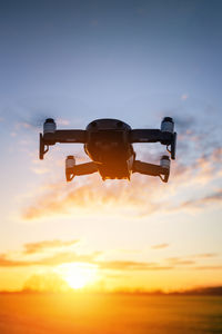 Low angle view of airplane against sky during sunset