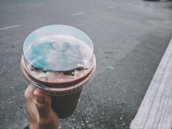 Close-up of hand holding dessert over street