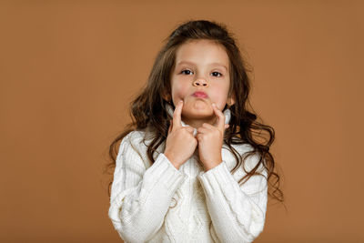 Portrait of young woman against yellow background