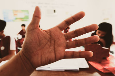 Cropped hand gesturing in classroom