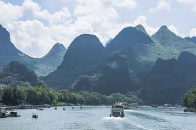 Boat on river against mountains