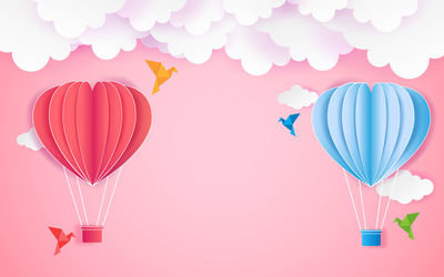 Multi colored hot air balloon flying over heart shape
