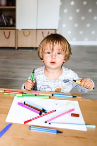 Little boy drawing with felt-tip pens