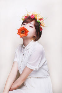 Portrait of young woman making face over white background