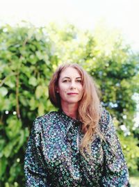 Portrait of smiling woman standing against plants