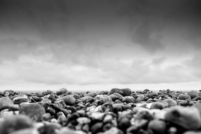 Surface level of rocks against cloudy sky