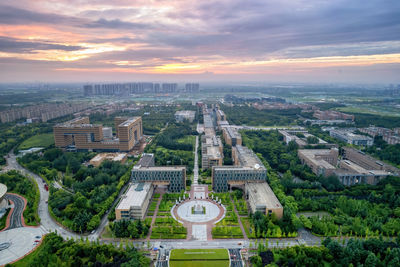 Aerial view of buildings in city at sunset