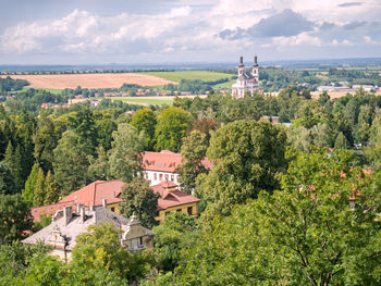 Luze village with hamzova hospital roofs and baroque church above park. czech republic