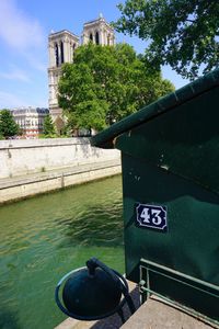 Close-up of boat by river in city against sky