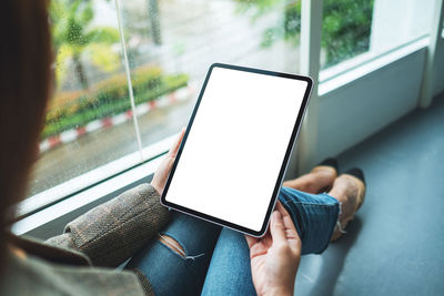 Midsection of woman using digital tablet