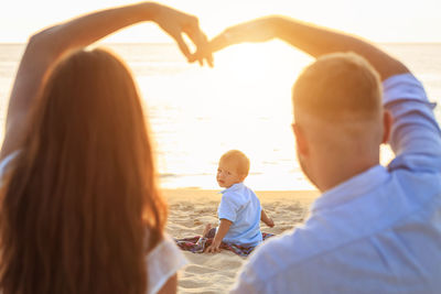 Rear view of couple kissing at beach